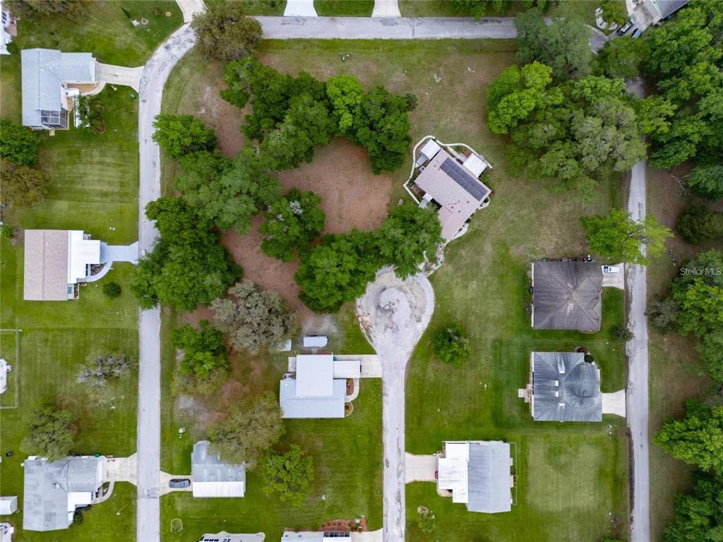 An aerial view shows several houses situated on large, tree-filled lots along a cul-de-sac — LOT 20 BLK D STRATFORD COURT, WILDWOOD, FL