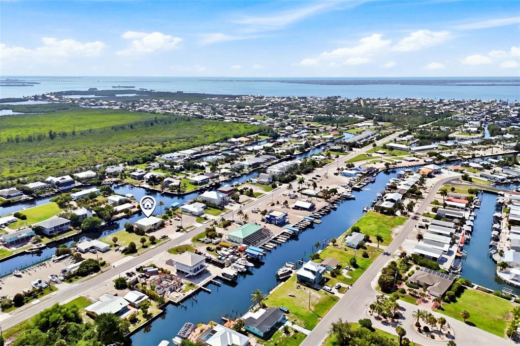 An aerial view shows a residential neighborhood with houses situated along multiple canals — 3226 STRINGFELLOW ROAD, ST JAMES CITY, FL