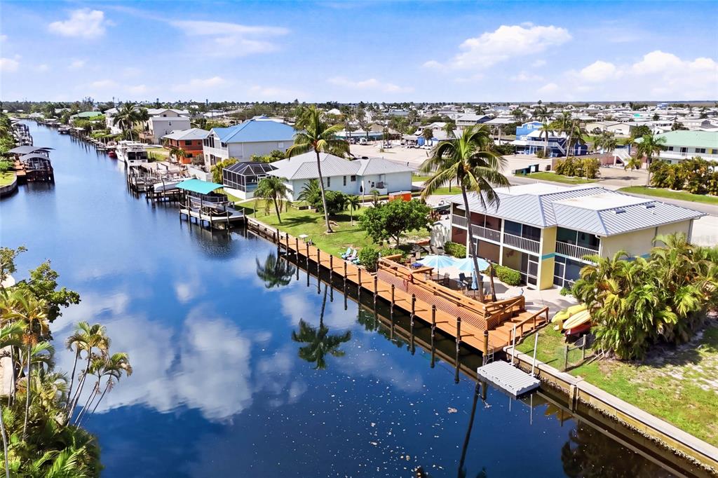An aerial view of a waterfront house with a wooden deck and boat dock — 3226 STRINGFELLOW ROAD, ST JAMES CITY, FL