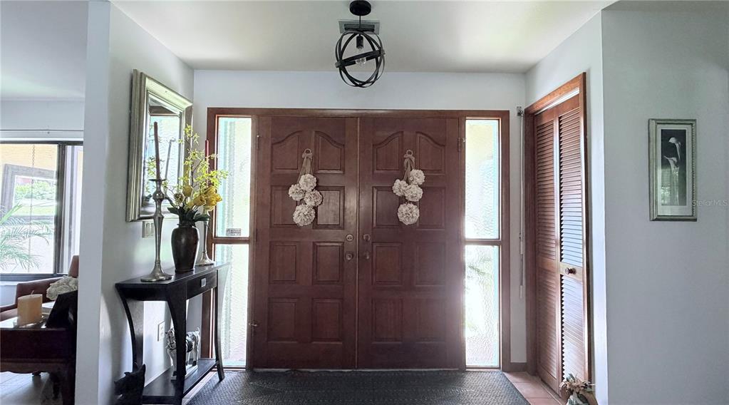 A patio with a table, chairs, and umbrella sits in front of a house entrance — 8057 DELAWARE DRIVE, WEEKI WACHEE, FL
