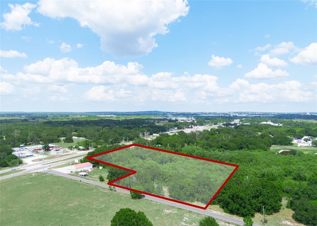 An aerial view shows a wooded lot outlined in red next to a paved road — SR-60, LAKE WALES, FL