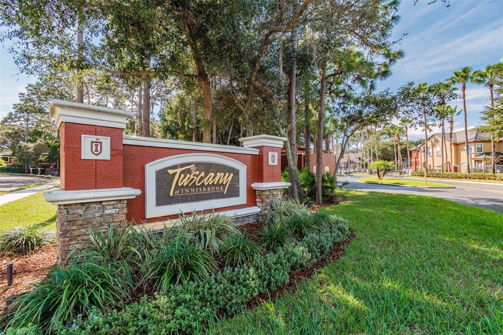 A stone and stucco monument sign marks the entrance to the Tuscany at Innisbrook community — 2151 CHIANTI PLACE UNIT 12-122, PALM HARBOR, FL