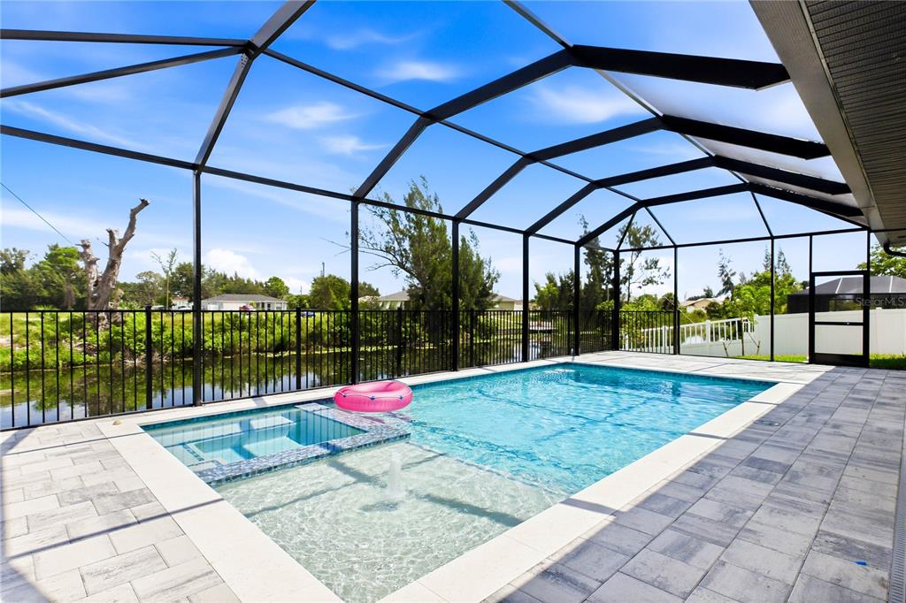 A screened-in swimming pool and spa with a fountain feature and paver patio — 2251 SW 2ND TERRACE, CAPE CORAL, FL