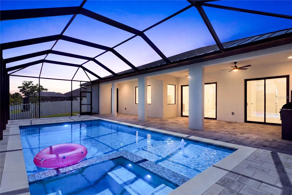 A screened-in patio features a swimming pool with a hot tub and a fountain — 2251 SW 2ND TERRACE, CAPE CORAL, FL