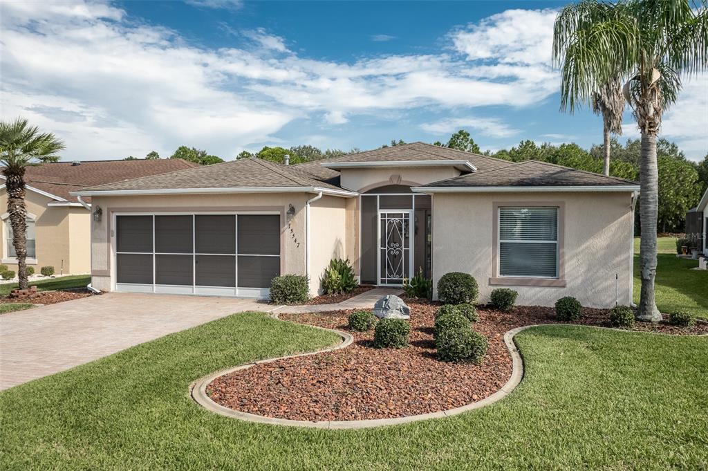 A single-story house with a screened garage, a front entryway, and a landscaped front yard — 15547 SW 13TH CIRCLE, OCALA, FL