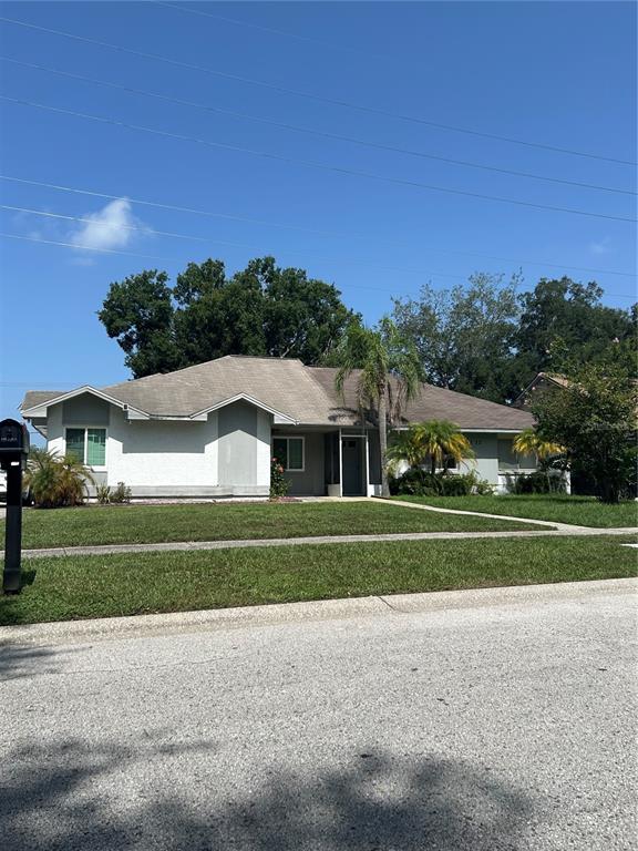 A single-story house with a light-colored exterior, a brown roof, and a front lawn — 3330 LAUREL DALE DRIVE, TAMPA, FL