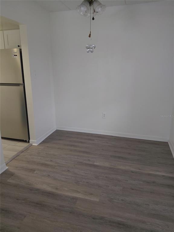 A dining area features light gray wood-look flooring, white walls, and a hanging light fixture — 4725 JOSEPH COURT UNIT 229, TAMPA, FL