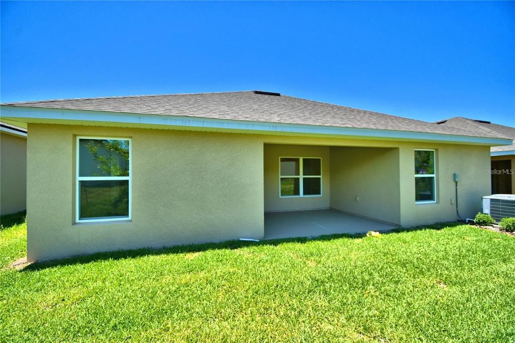 The exterior rear view of a house shows a covered patio and a grassy yard — 3640 LINDBERGH STREET, LAKELAND, FL