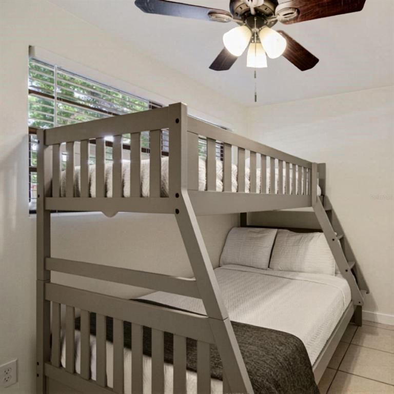 A bedroom features a gray wooden bunk bed with a lower full-sized mattress — 1202 PRINCETON RD, COCOA, FL