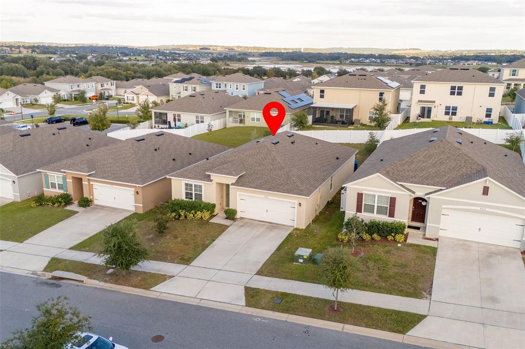 An aerial view shows a suburban single-family home with a tan exterior and shingled roof — 9537 BLACK WALNUT DRIVE, CLERMONT, FL