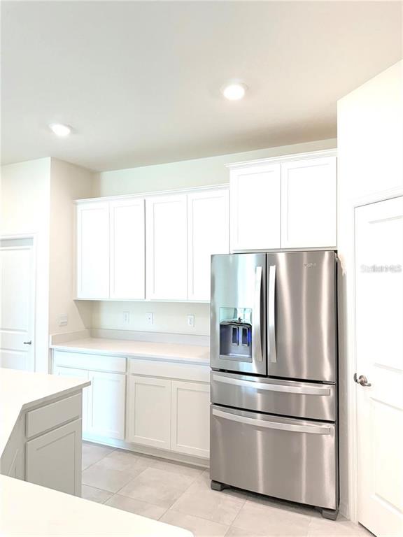 A kitchen features white shaker cabinets, stainless steel appliances, and light-colored countertops — 4730 NW 39TH STREET ROAD, OCALA, FL