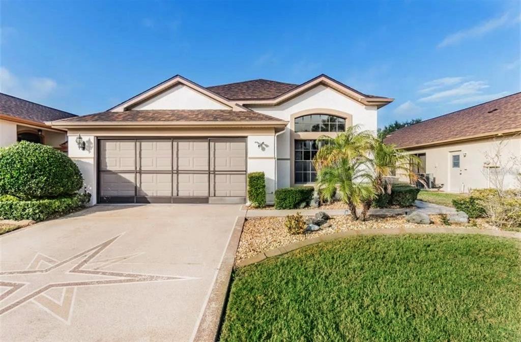 A single-story house with a two-car garage, a concrete driveway, and a landscaped front yard — 13825 LEROUX DRIVE, HUDSON, FL