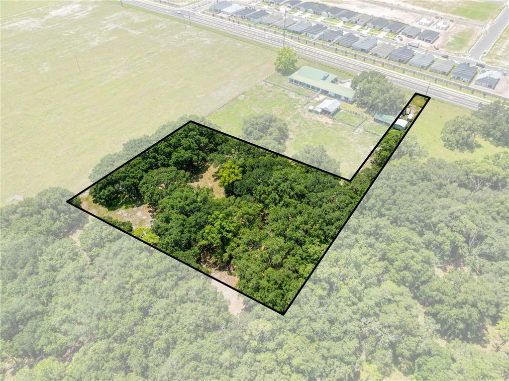 An aerial view shows a wooded, L-shaped plot of land outlined in black — 0 HICKORY TREE RD. SAINT CLOUD, FL UNIT 34772, ST CLOUD, FL