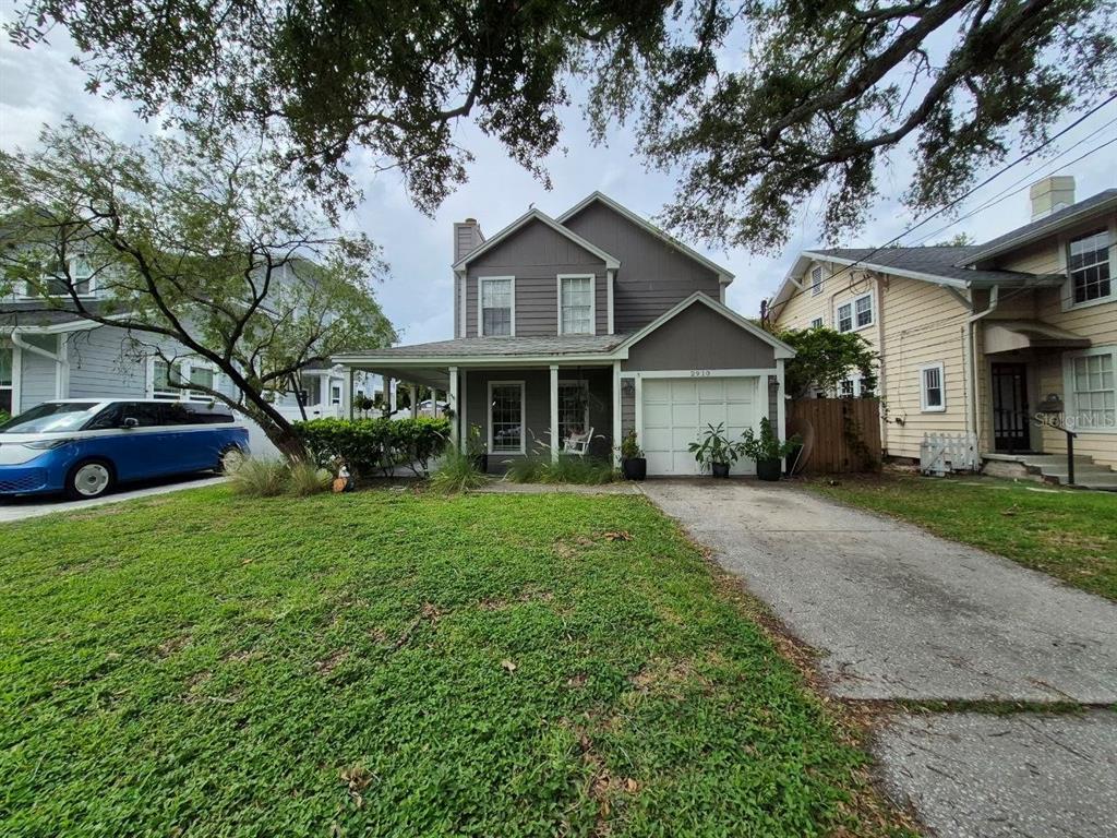 A two-story gray house with a front porch, garage, and a concrete driveway — 2910 W SITIOS STREET, TAMPA, FL