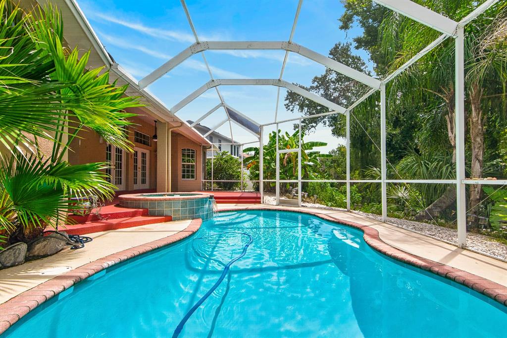 A swimming pool and spa are enclosed within a screened lanai next to a house — 2007 RIVER CROSSING DRIVE, VALRICO, FL
