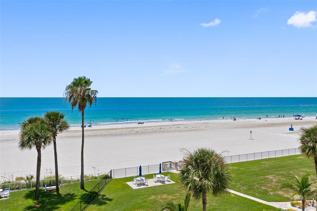 A view of a sandy beach and the ocean from an elevated outdoor balcony — 17980 GULF BOULEVARD UNIT 401, REDINGTON SHORES, FL