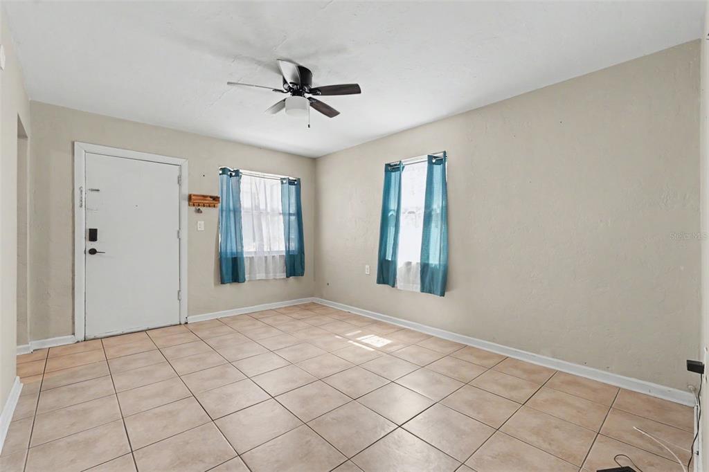 A living room features a beige sofa, a wooden coffee table, and a wall-mounted television — 1946 15TH AVENUE S, ST PETERSBURG, FL