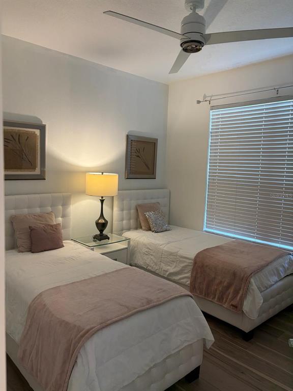 A bedroom features two twin beds with white tufted headboards and pink bedding — 1537 TRANQUIL AVENUE, CLERMONT, FL