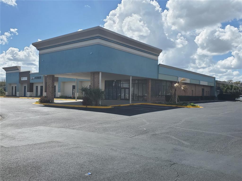 This is a rendering of a modern commercial building with a covered entrance and parking — 7900 S ORANGE BLOSSOM TRAIL UNIT 1120, ORLANDO, FL