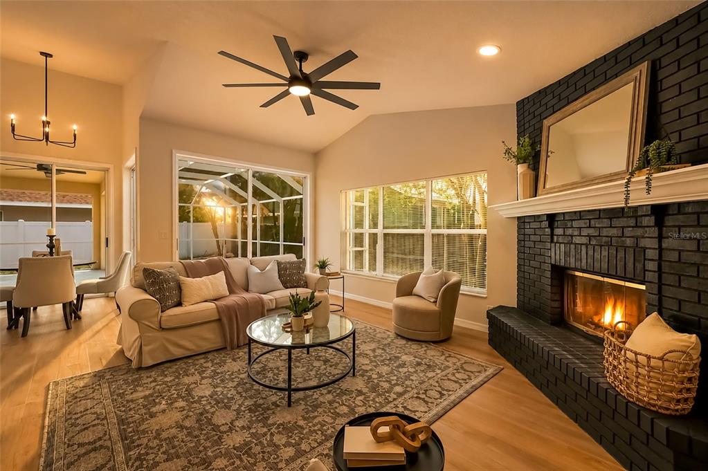 A living room features a black brick fireplace, beige sofa, and a ceiling fan — 1887 WOOD BEND STREET, TARPON SPRINGS, FL