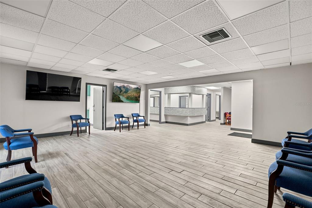 A waiting room features blue chairs, wood-look tile flooring, and a reception desk area — 901 N GROVE STREET, EUSTIS, FL
