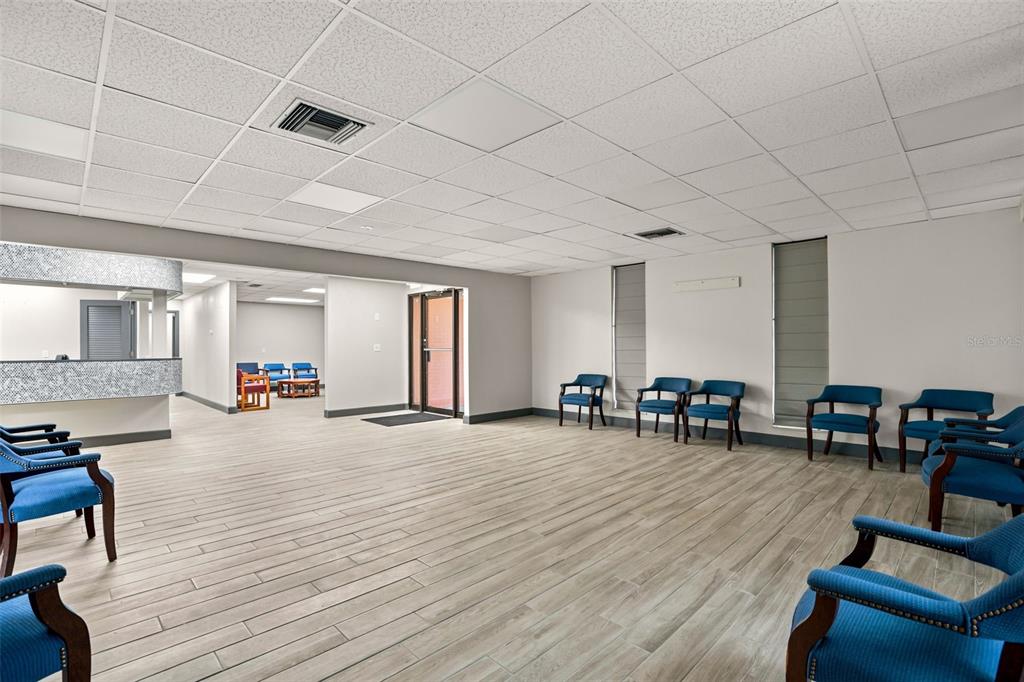 A waiting room features blue chairs, light wood-look flooring, and a drop ceiling — 901 N GROVE STREET, EUSTIS, FL