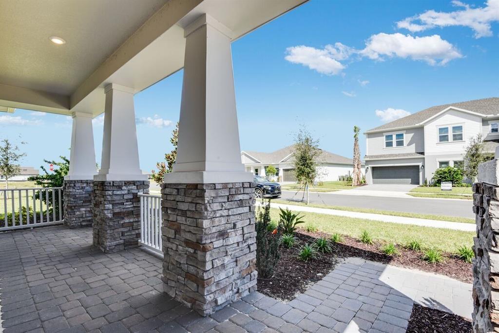 A modern kitchen features white cabinetry, quartz countertops, stainless steel appliances, and a marble backsplash — 672 JUNONIA BOULEVARD, NEW SMYRNA BEACH, FL