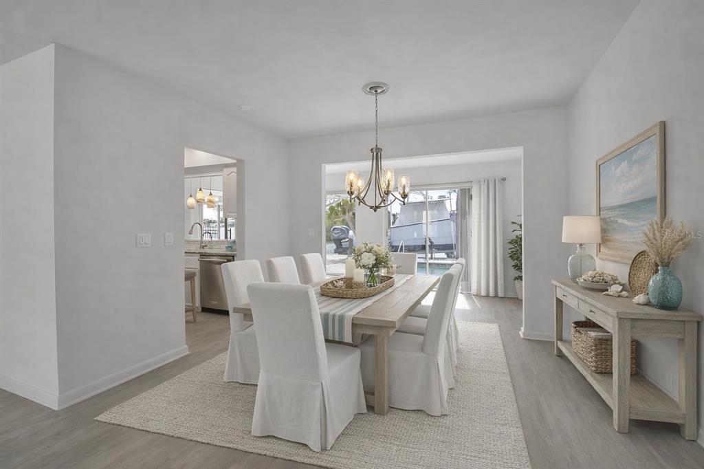 An aerial view shows a waterfront house with a pool, boat dock, and landscaped grounds — 922 CASEY COVE DRIVE, NOKOMIS, FL