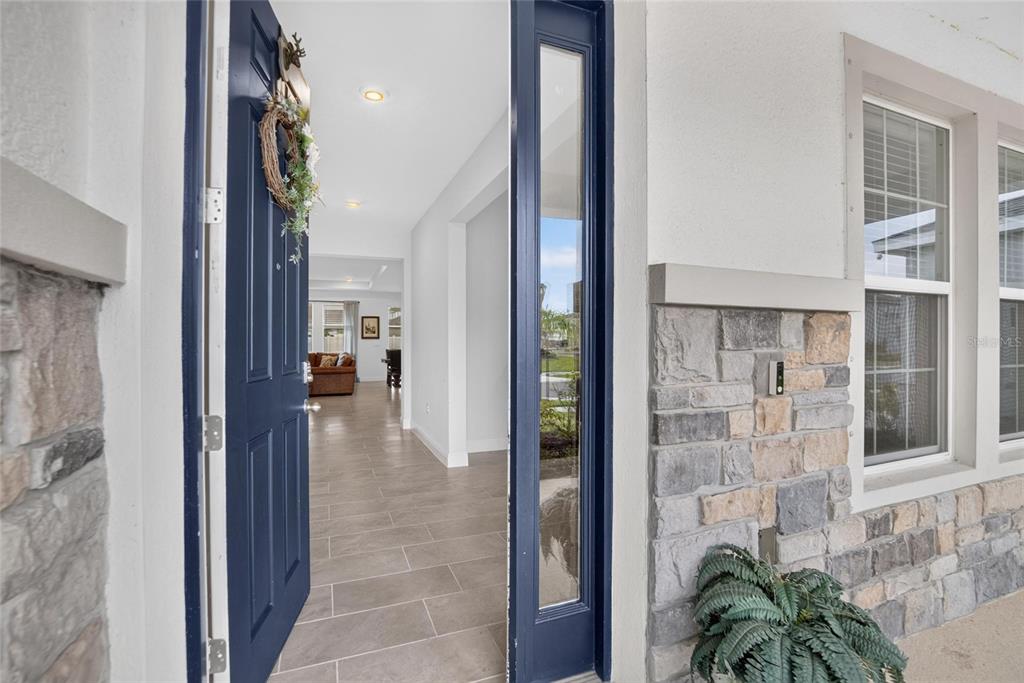 A blue front door opens into a tiled entryway with a view of the living room — 5633 HAWKS CAY STREET, APOLLO BEACH, FL