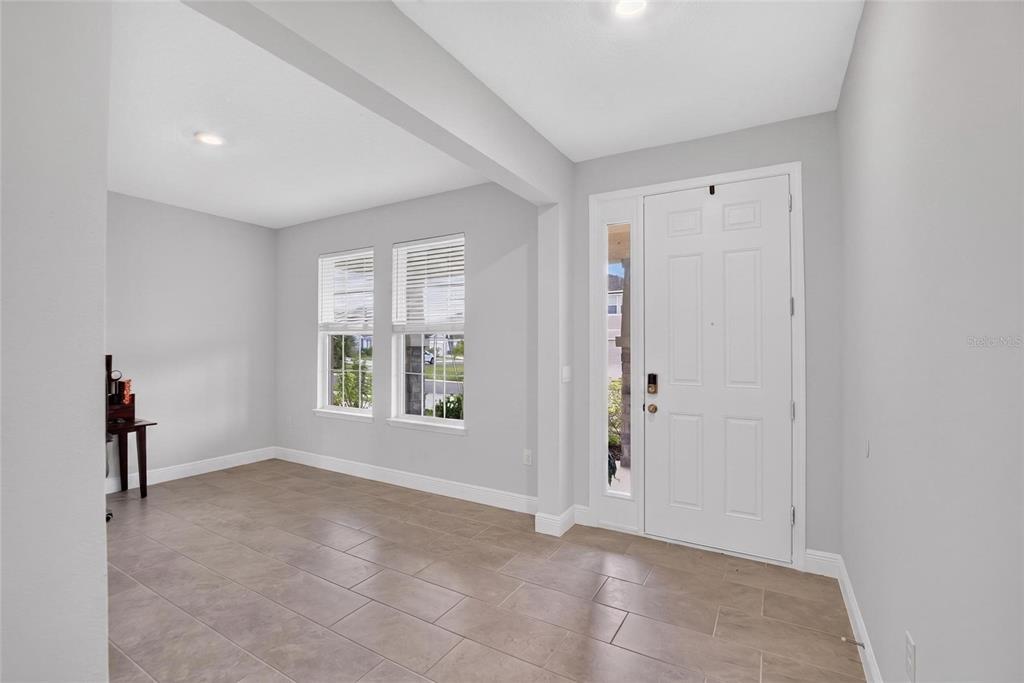 An entryway with light gray walls, tile flooring, and a white front door with sidelight — 5633 HAWKS CAY STREET, APOLLO BEACH, FL