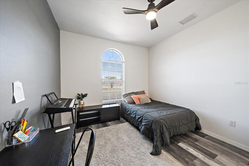 A modern kitchen features white cabinets, granite countertops, a farmhouse sink, and exposed ceiling beams — 26410 80TH DRIVE E, MYAKKA CITY, FL