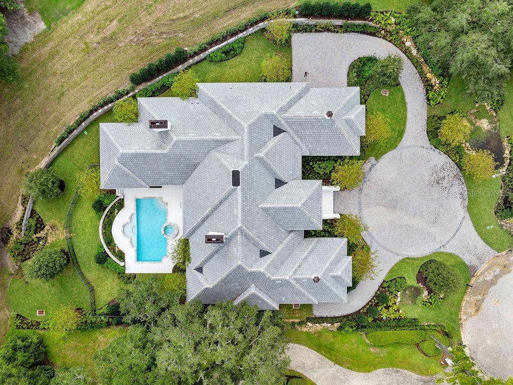 An aerial view shows a large house with a gray roof, pool, and circular driveway — 4015 NW 85TH TERRACE, OCALA, FL