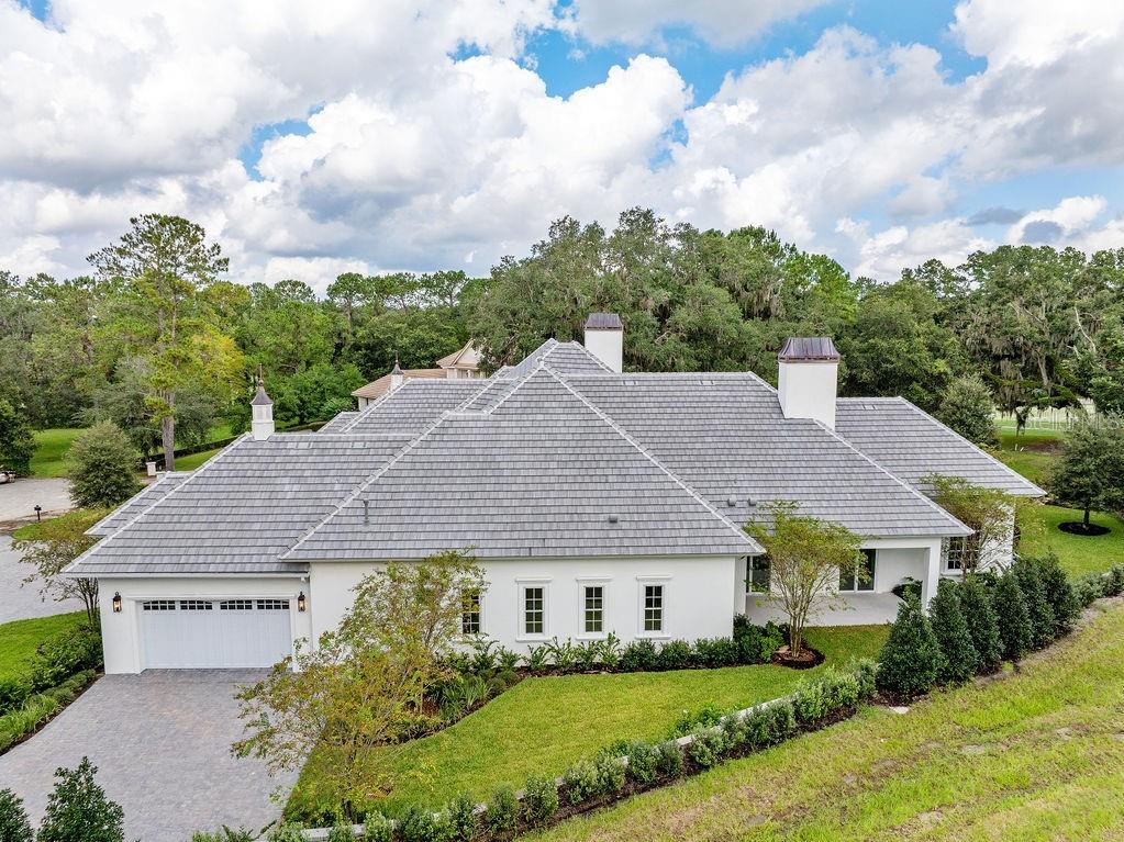 An aerial view of a white single-story house with a gray tiled roof and garage — 4015 NW 85TH TERRACE, OCALA, FL