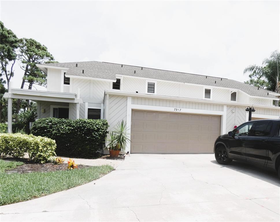 A two-story house with white siding, a tan garage door, and a concrete driveway — 7917 PINEGROVE COURT UNIT 1, SARASOTA, FL