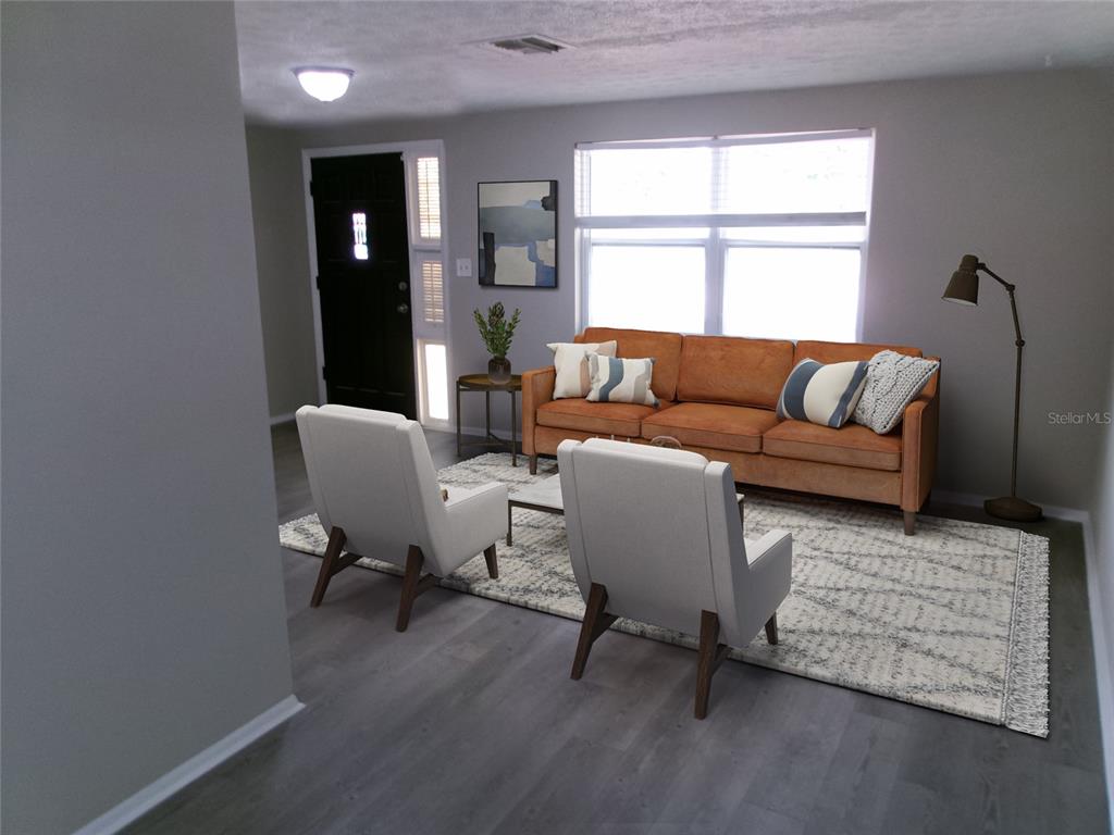A living room features a tan sofa, two white armchairs, and a patterned rug — 1421 NORMANDY BOULEVARD, HOLIDAY, FL
