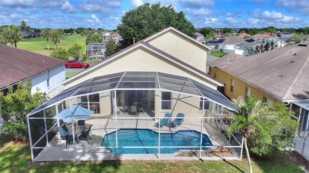 An aerial view shows a house with a screened-in pool and patio area — 653 JAYBEE AVENUE, DAVENPORT, FL