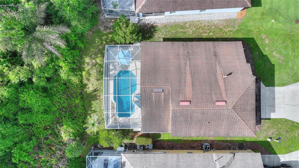 A covered patio features a dining set, a ceiling fan, and a screened-in swimming pool — 653 JAYBEE AVENUE, DAVENPORT, FL