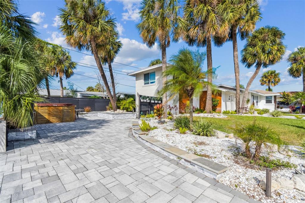 A paved driveway leads to a two-story house surrounded by palm trees and landscaping — 760 BOHENIA CIRCLE S, CLEARWATER BEACH, FL