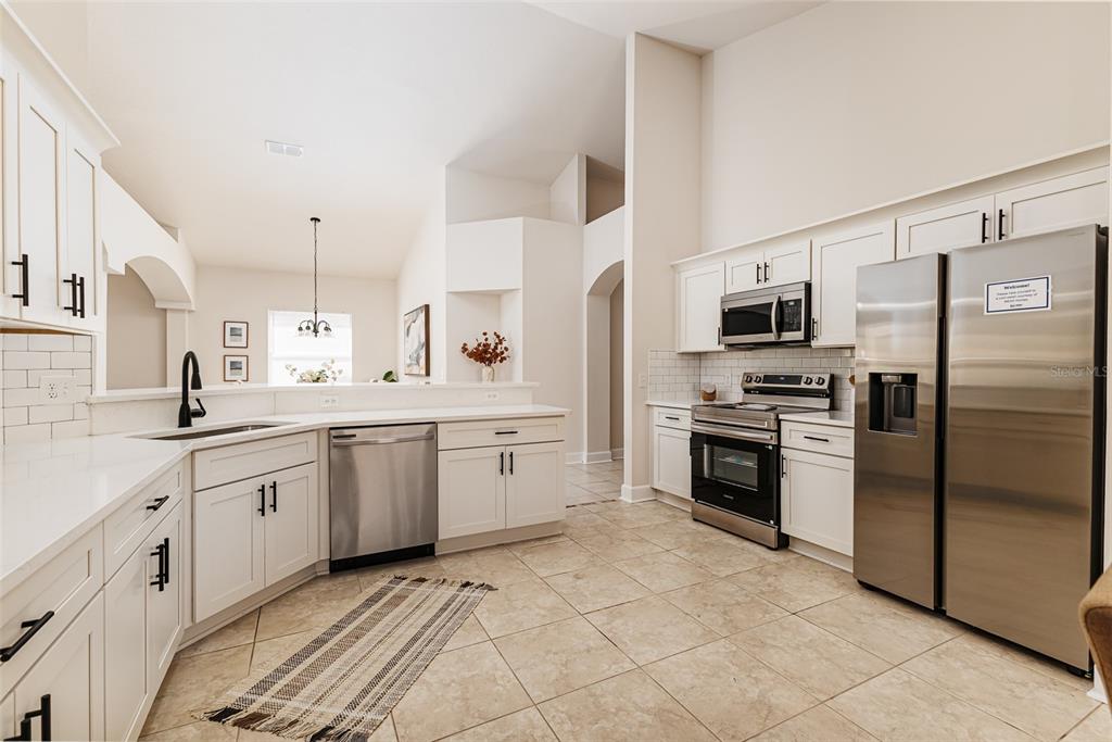 A kitchen with white cabinets, stainless steel appliances, and tile flooring — 1705 ALTAVISTA CIRCLE, LAKELAND, FL