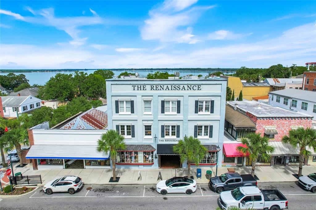 An aerial view of a three-story blue building named The Renaissance on a street — 411 N DONNELLY ST, MOUNT DORA, FL