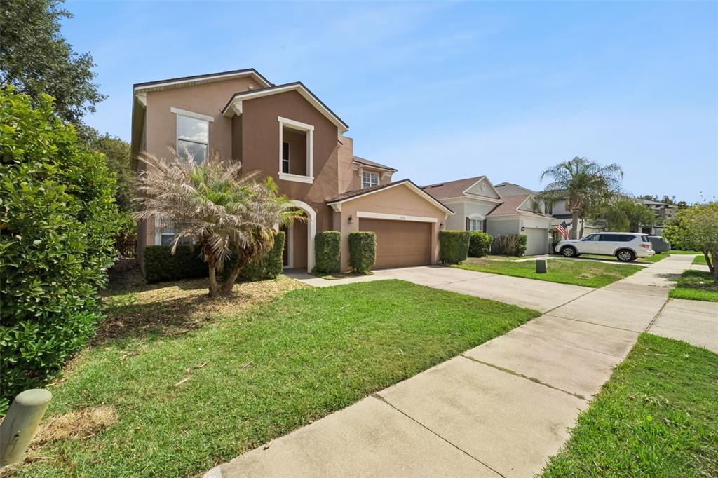 A two-story suburban house with a brown exterior, a two-car garage, and a front lawn — 5056 GANDROSS LANE, MOUNT DORA, FL