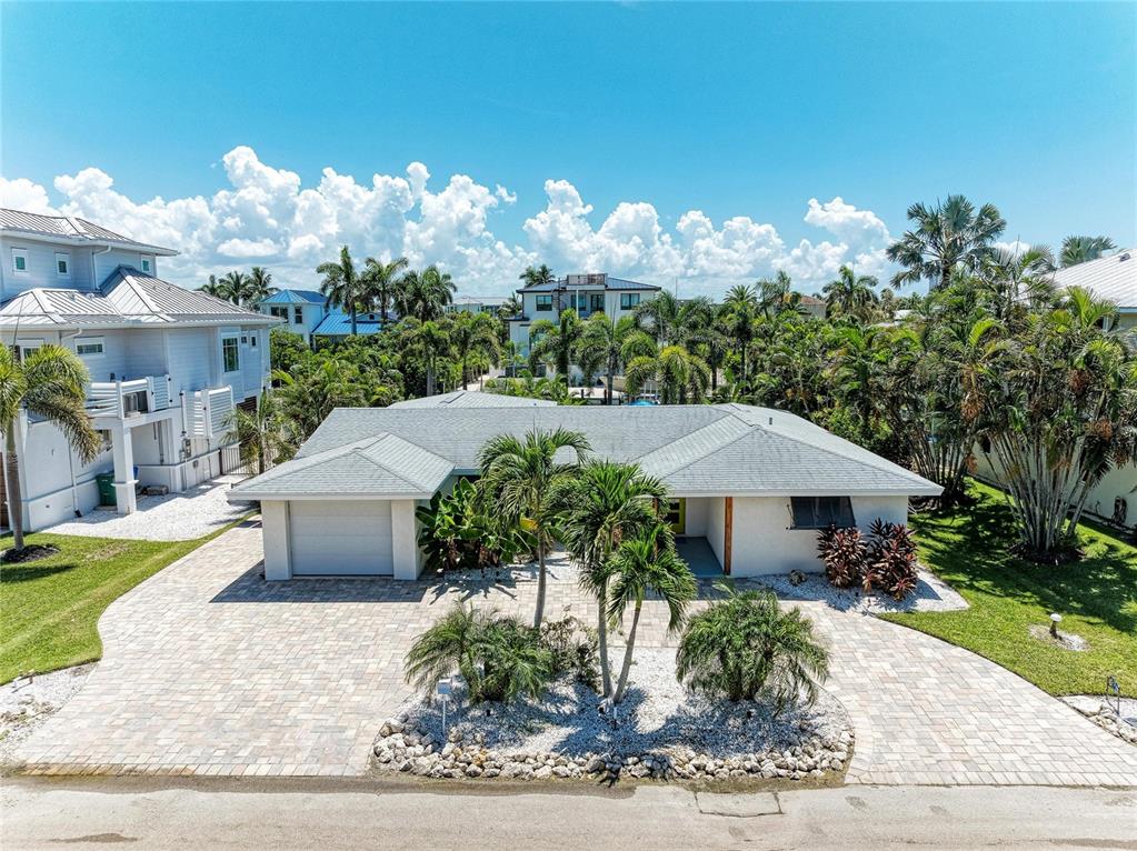 A single-story house with a paved driveway, palm trees, and a gray shingled roof — 714 NORTON STREET, LONGBOAT KEY, FL