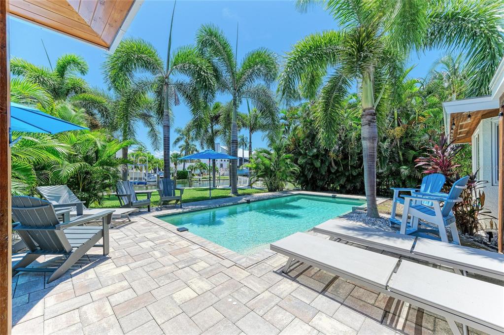A backyard swimming pool with a stone patio, lounge chairs, and palm trees — 714 NORTON STREET, LONGBOAT KEY, FL