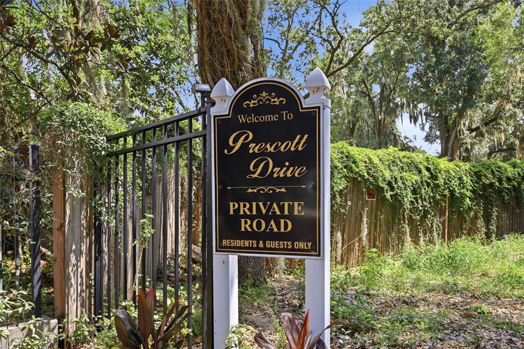 A sign for Prescott Drive stands in front of a black metal gate and fence — 238 PRESCOTT DRIVE, ORLANDO, FL