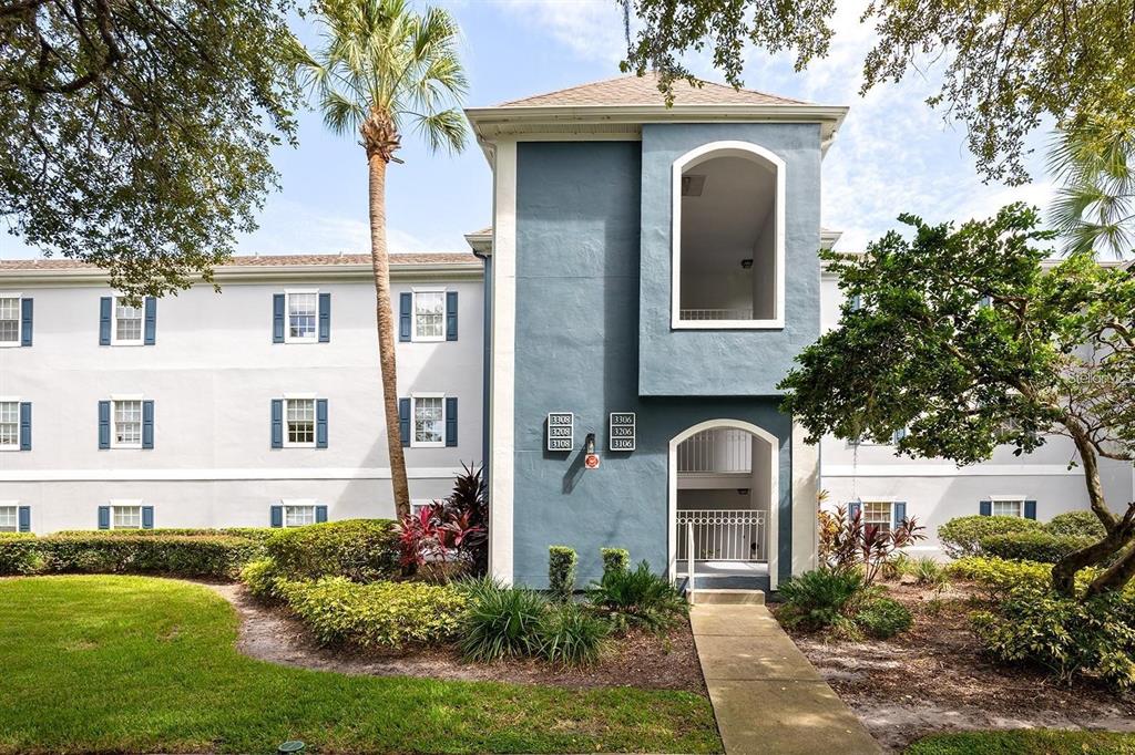 A multi-story apartment building exterior features a blue central tower with unit number signage — 3206 CLUBSIDE DRIVE UNIT 3206, LONGWOOD, FL