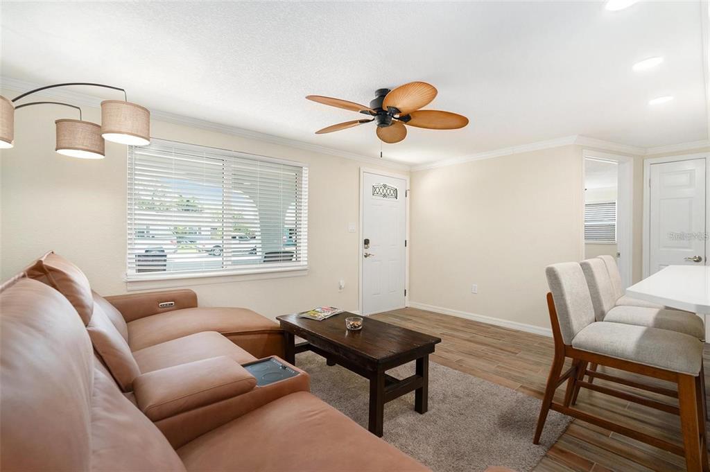 A living room features a tan sectional sofa, a wooden coffee table, and a ceiling fan — 13401 NEPTUNE DRIVE, HUDSON, FL