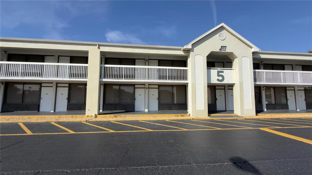 An aerial view shows a multi-story apartment complex with a central swimming pool and courtyard — 5245 W IRLO BRONSON MEM HWY 165, KISSIMMEE, FL