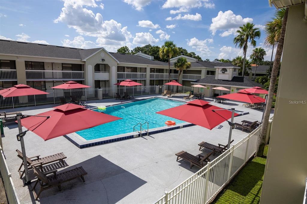 A single-story commercial building features a covered entrance, palm trees, and a paved parking lot — 5245 W IRLO BRONSON MEM HWY 165, KISSIMMEE, FL