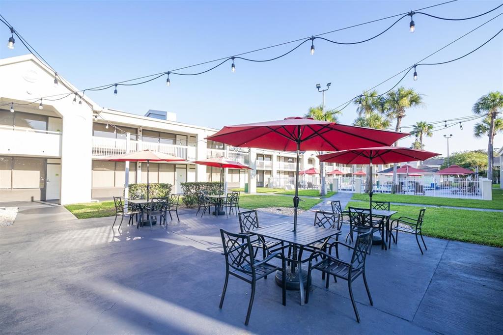 A two-story motel exterior features white railings, a central entrance marked with a number five — 5245 W IRLO BRONSON MEM HWY 165, KISSIMMEE, FL