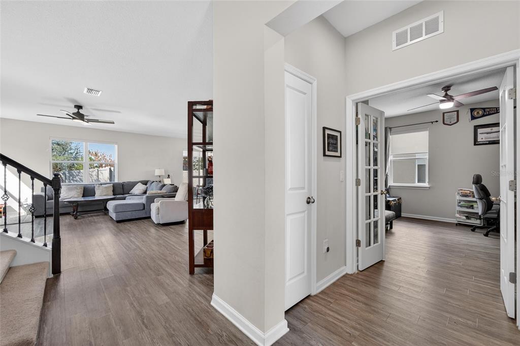 A view from a hallway looking into a living room and a home office — 12273 BLUE PACIFIC DRIVE, RIVERVIEW, FL